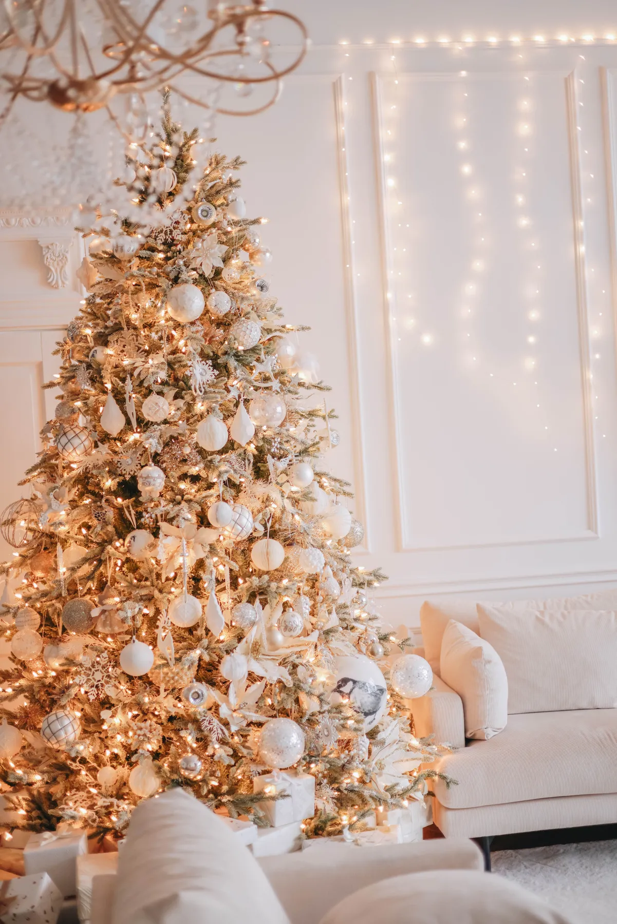 A beautifully decorated Christmas tree with lights in a cozy living room.