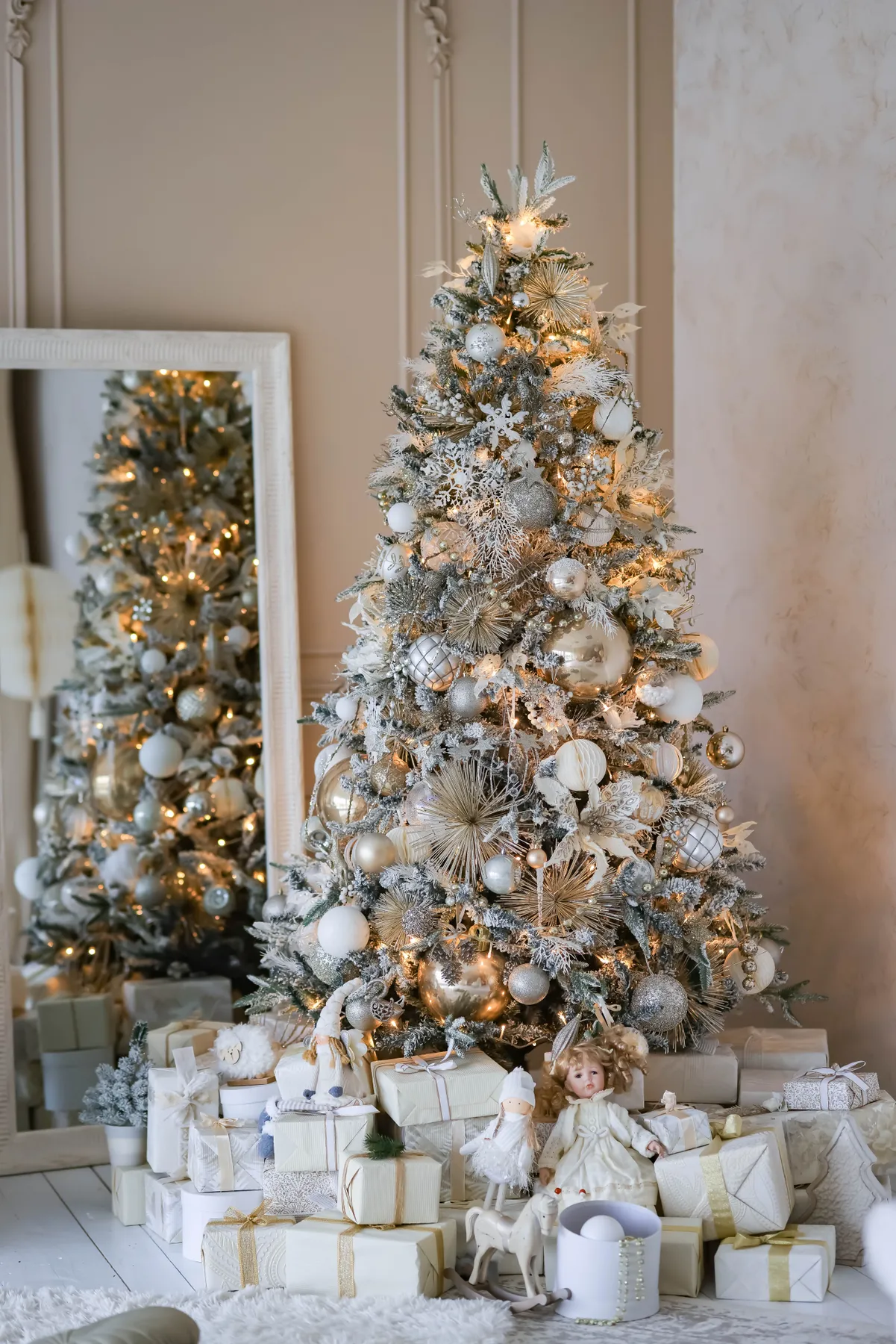 A beautifully decorated Christmas tree with gifts and holiday decorations inside a cozy home.