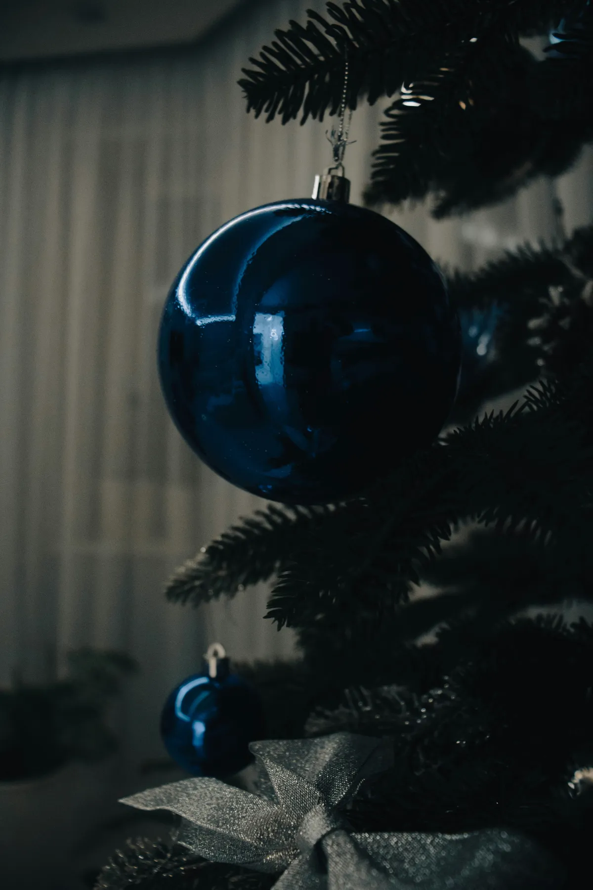 a blue ornament hanging from a christmas tree
