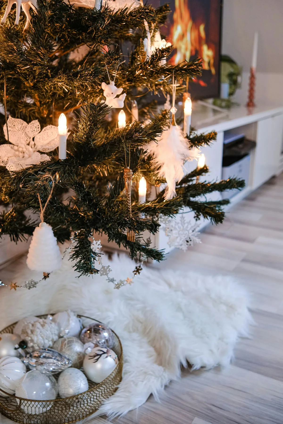 a christmas tree with a basket of ornaments in front of it