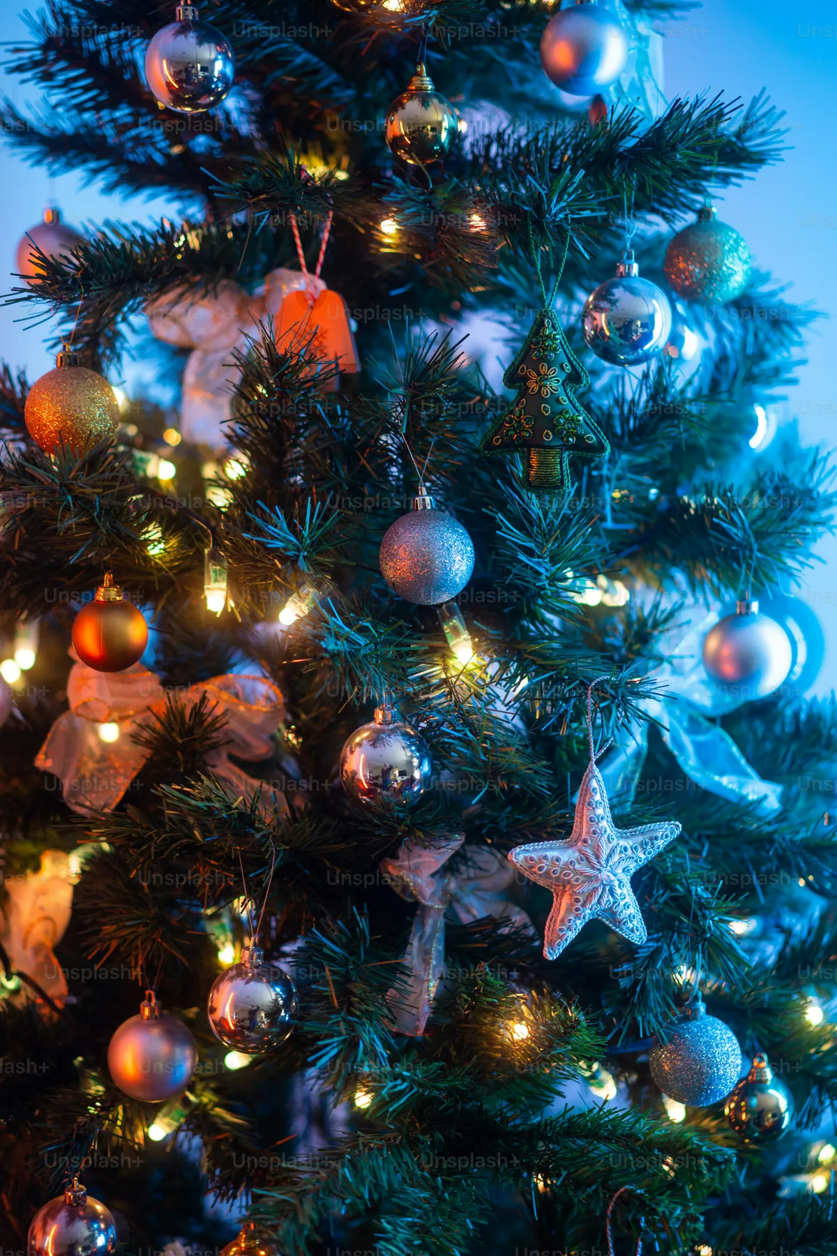 A close up of a christmas tree with ornaments - Photo on Unsplash+