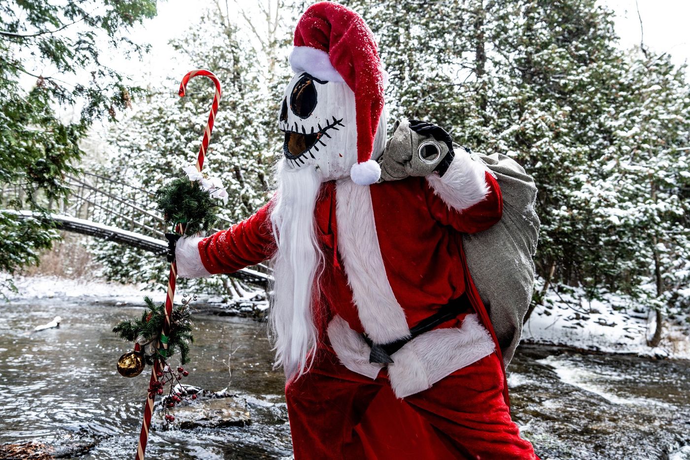 A costumed Santa character with a spooky twist poses in a snowy forest, creating a whimsical and festive atmosphere.
