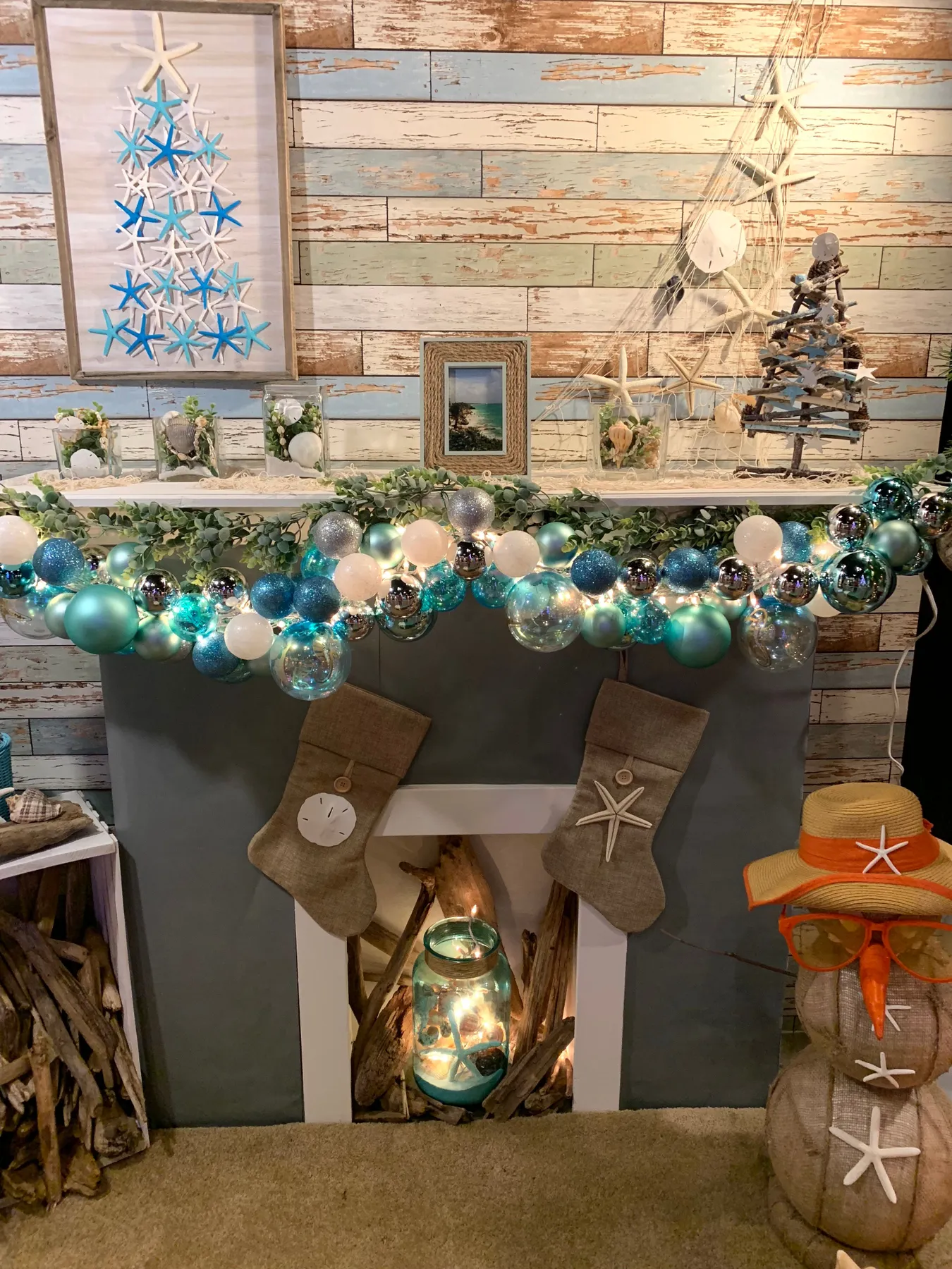 A festive coastal-themed Christmas mantel with turquoise and white ornaments.