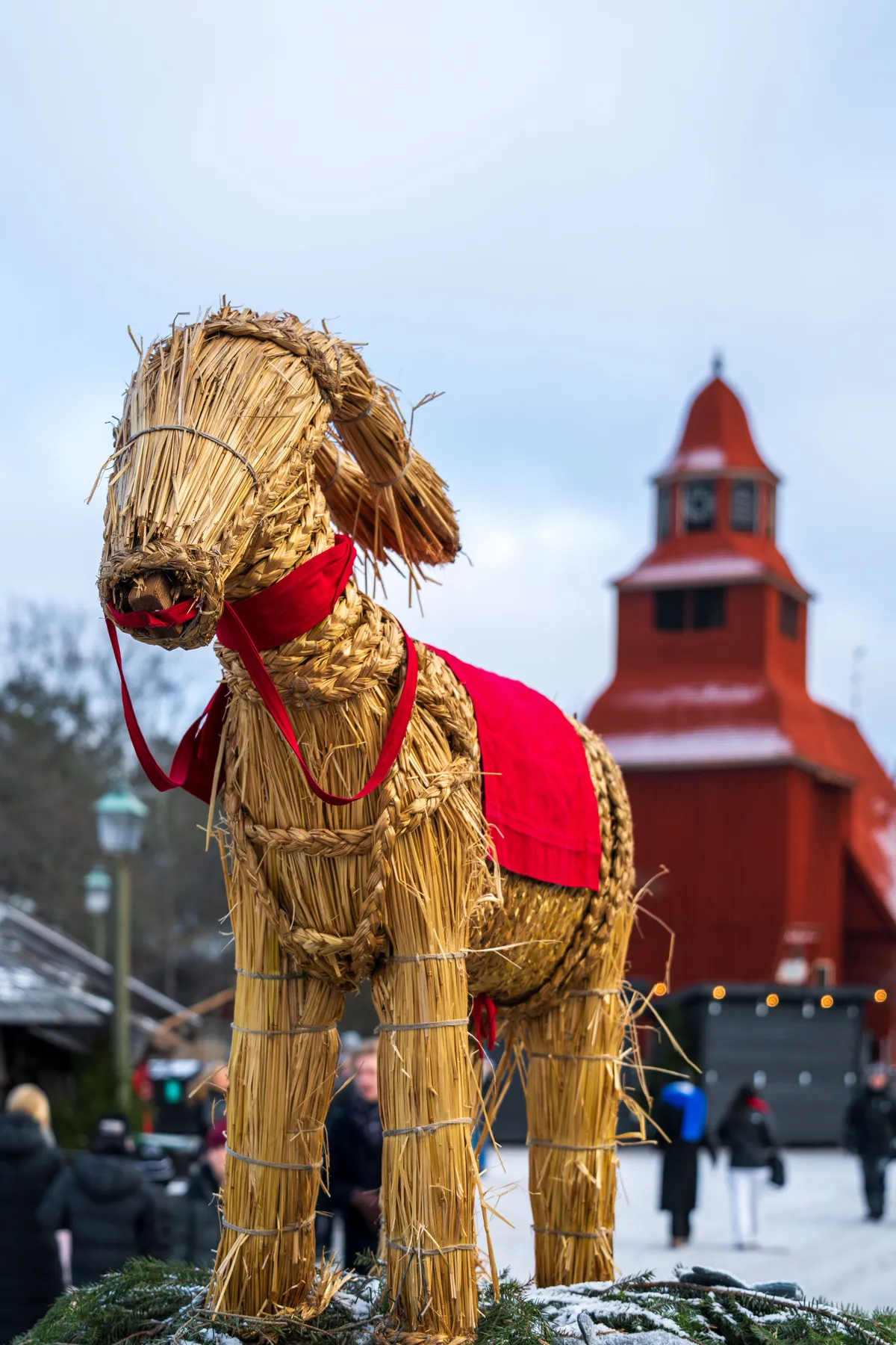 A festive straw goat stands in front of Seglora Church at Skansen, Stockholm, Sweden.