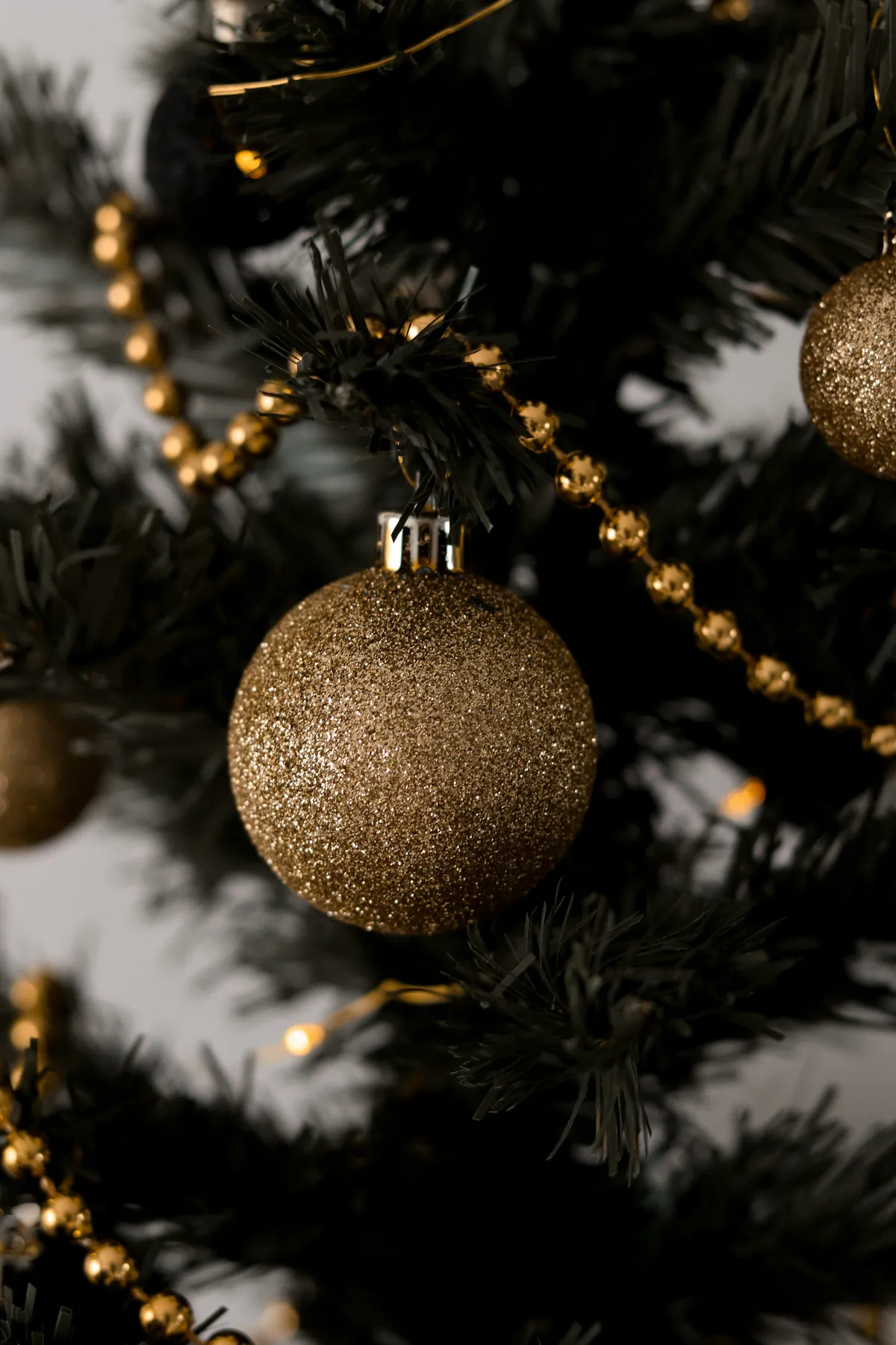 A small christmas tree with black and gold ornaments - Free Photo on  Unsplash