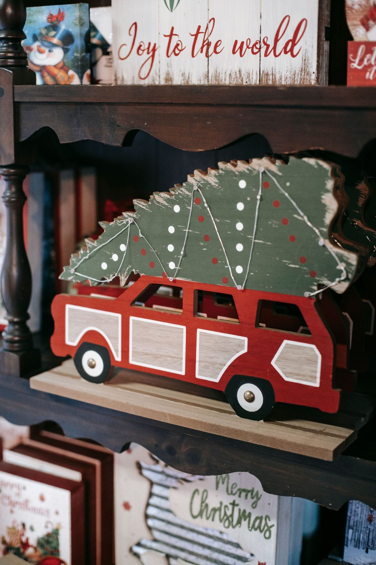 Bright wooden transport with Christmas tree near decorative boxes with festive inscriptions during New Year holiday