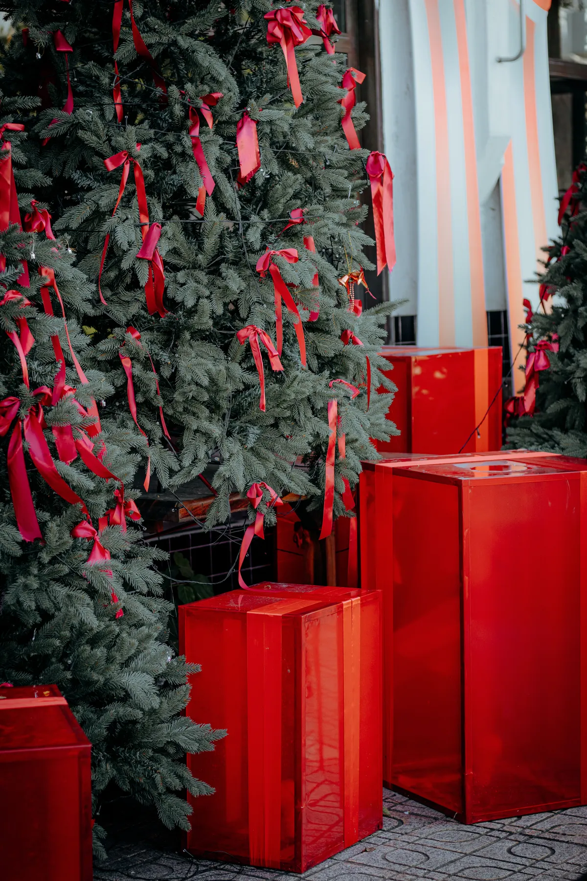 Christmas tree adorned with red ribbons and gifts, creating a festive atmosphere.