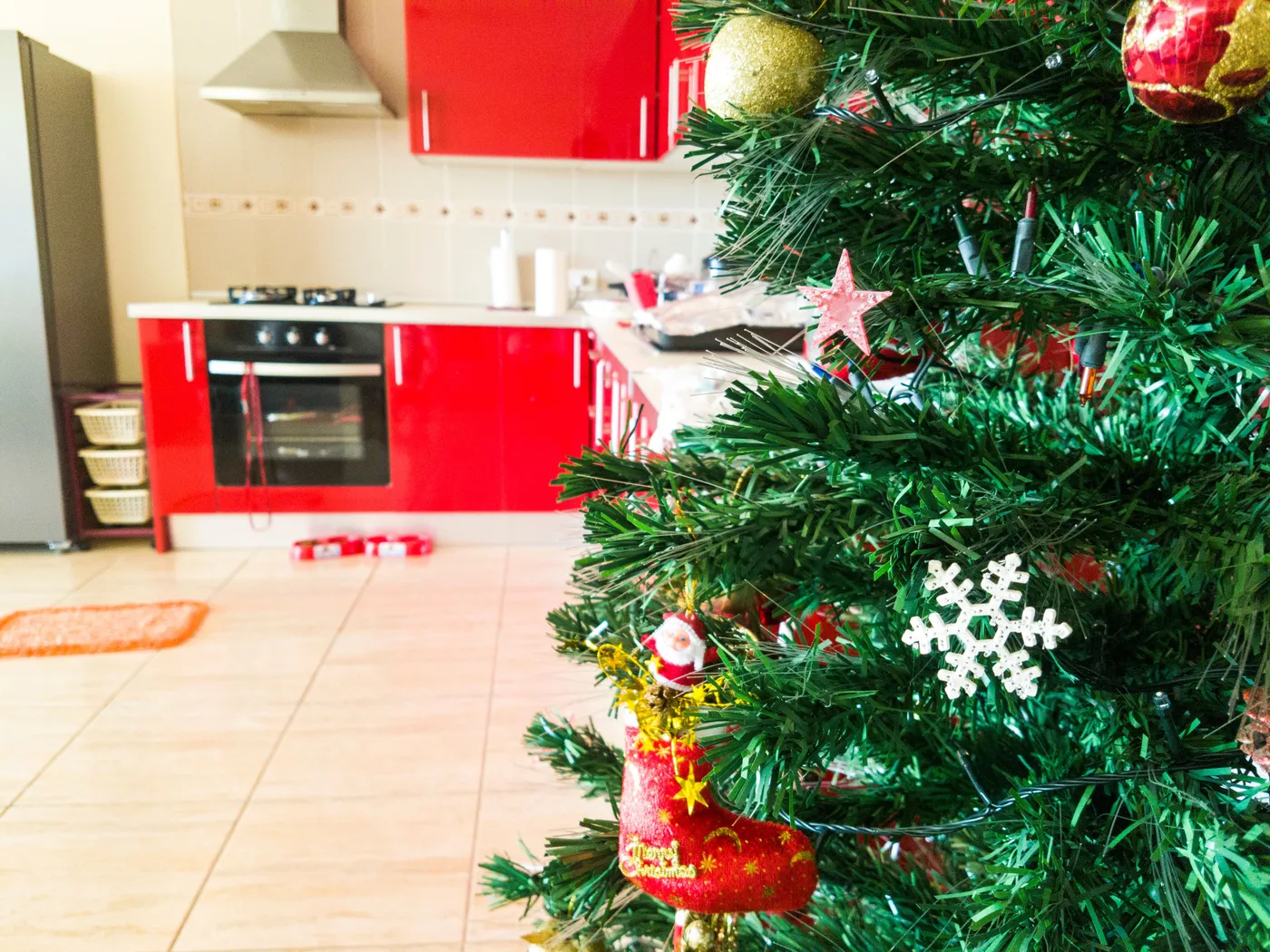 Christmas tree with decorations in a modern kitchen, capturing festive holiday vibes indoors.