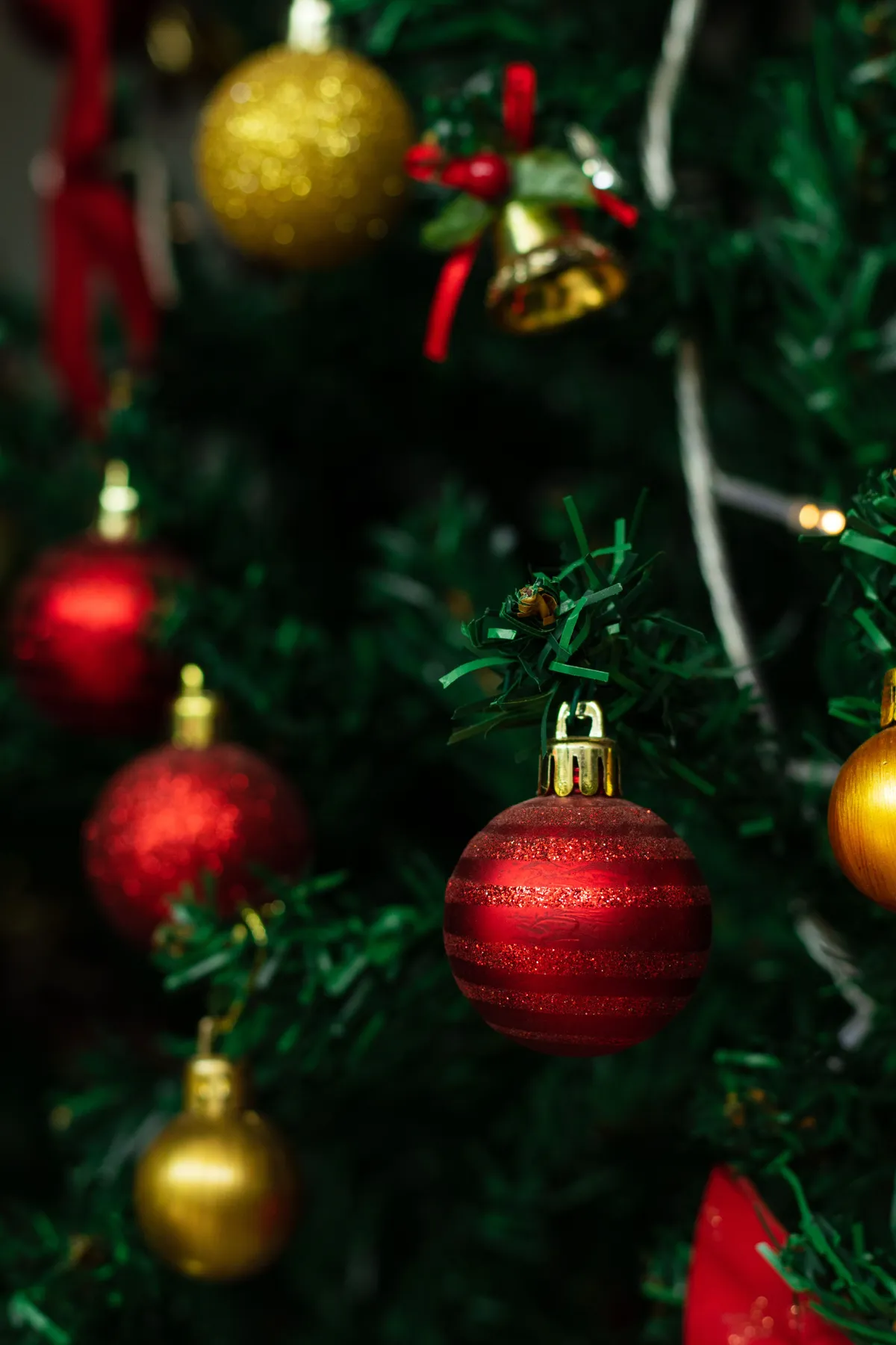 Close-up of a decorated Christmas tree with red and gold ornaments, creating a festive atmosphere.