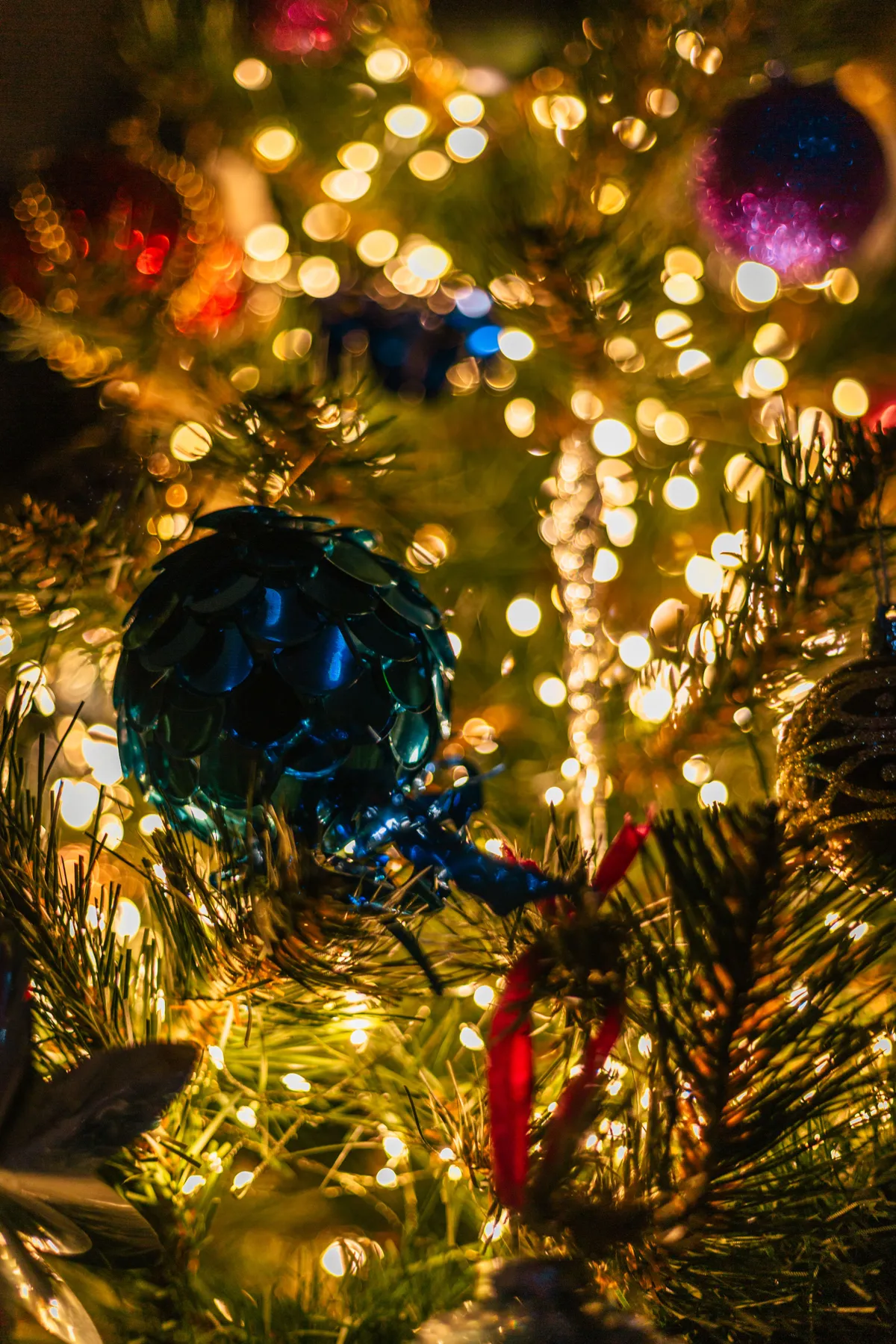 Close-up of a decorated Christmas tree with colorful ornaments and lights, creating a warm holiday atmosphere.