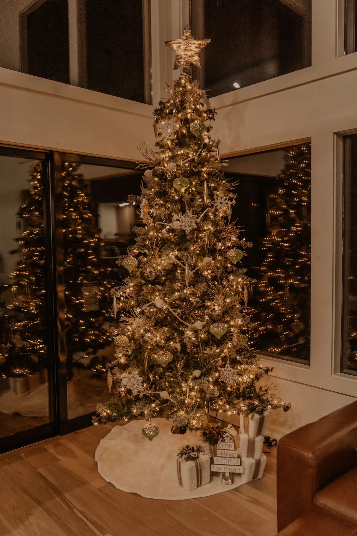 Cozy indoor setting featuring a beautifully decorated Christmas tree with golden ornaments and gifts.