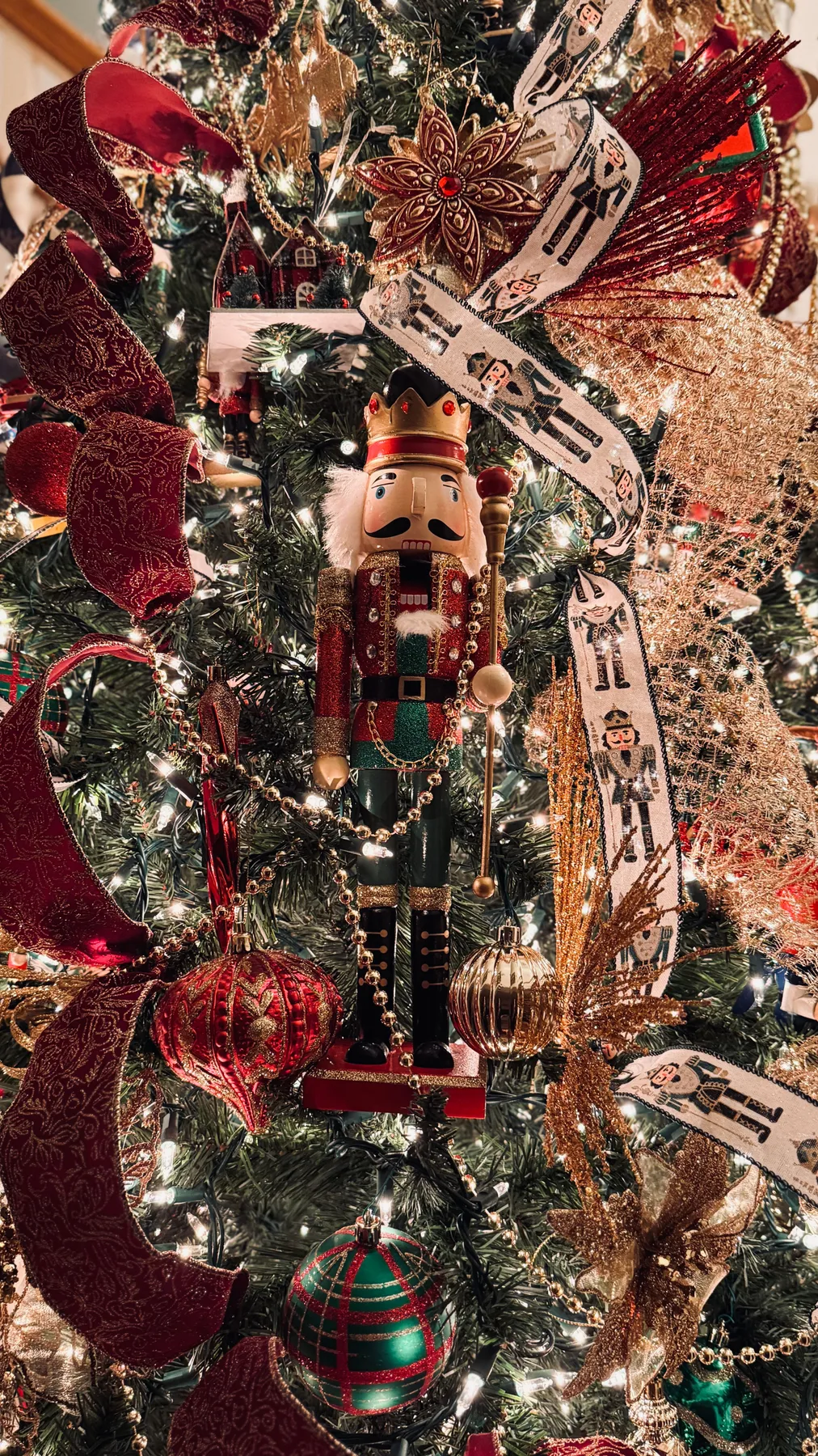Detailed Christmas tree adorned with nutcracker and ornaments, exuding festive spirit.