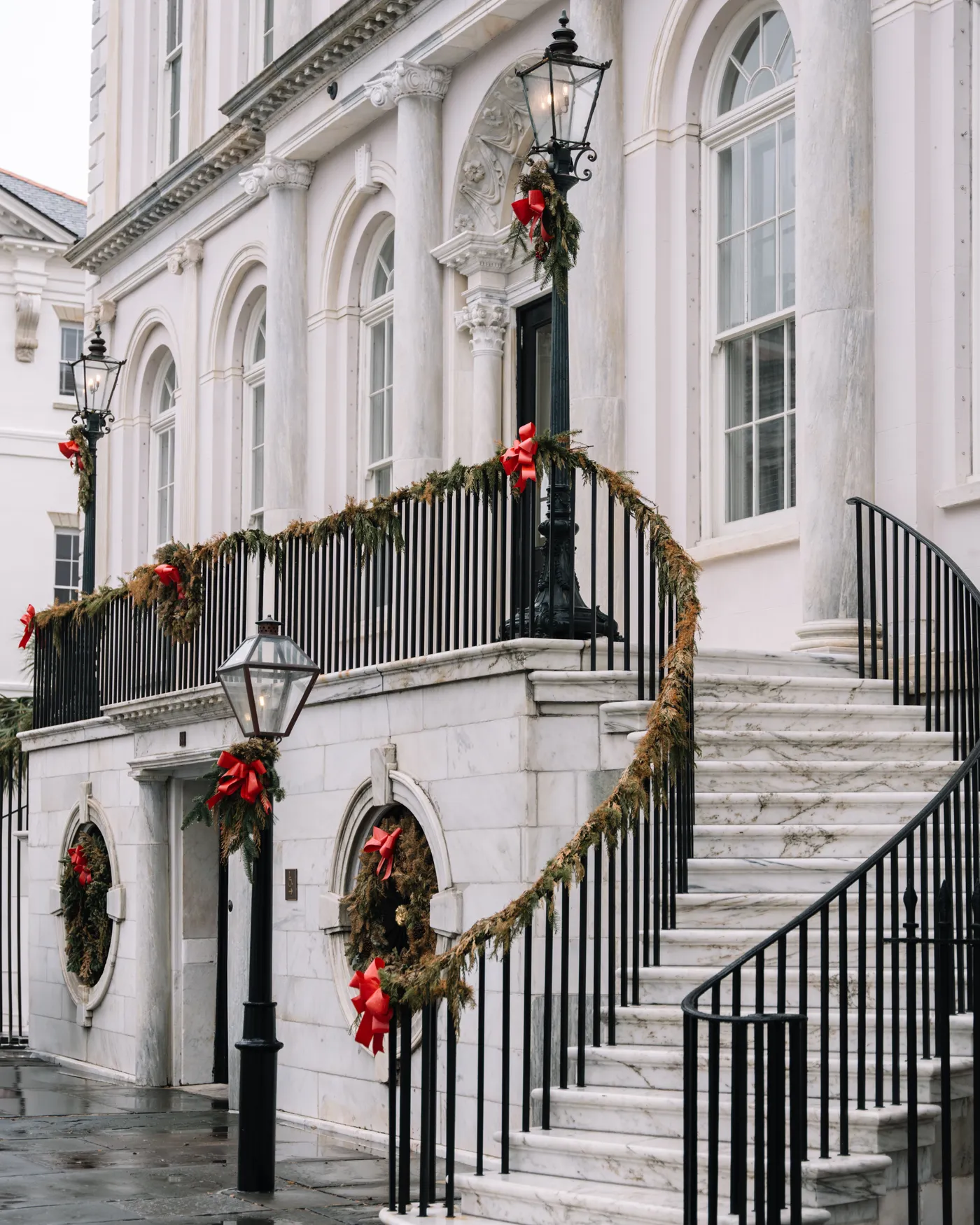 Elegant historic building in Charleston adorned with festive Christmas decorations.