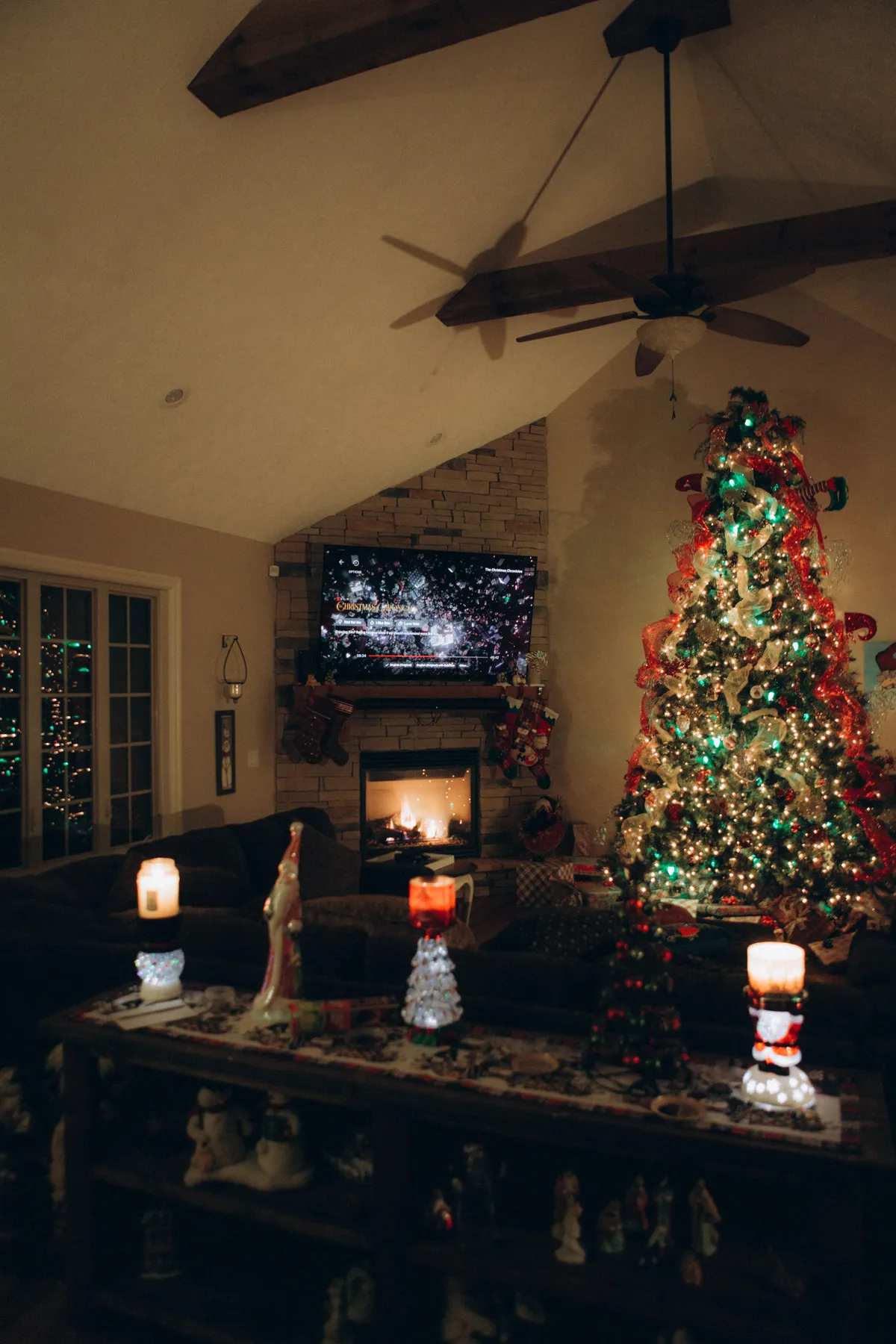 Festive living room setting with a decorated Christmas tree, fireplace, and holiday ornaments.