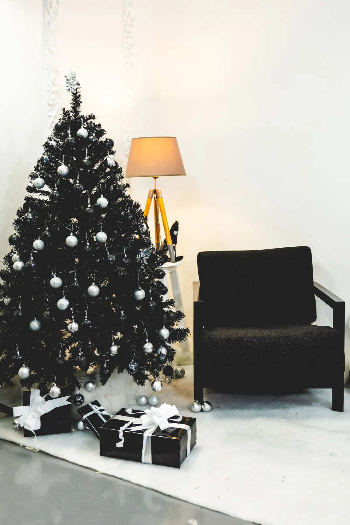 Modern living room with a decorated Christmas tree and wrapped presents.