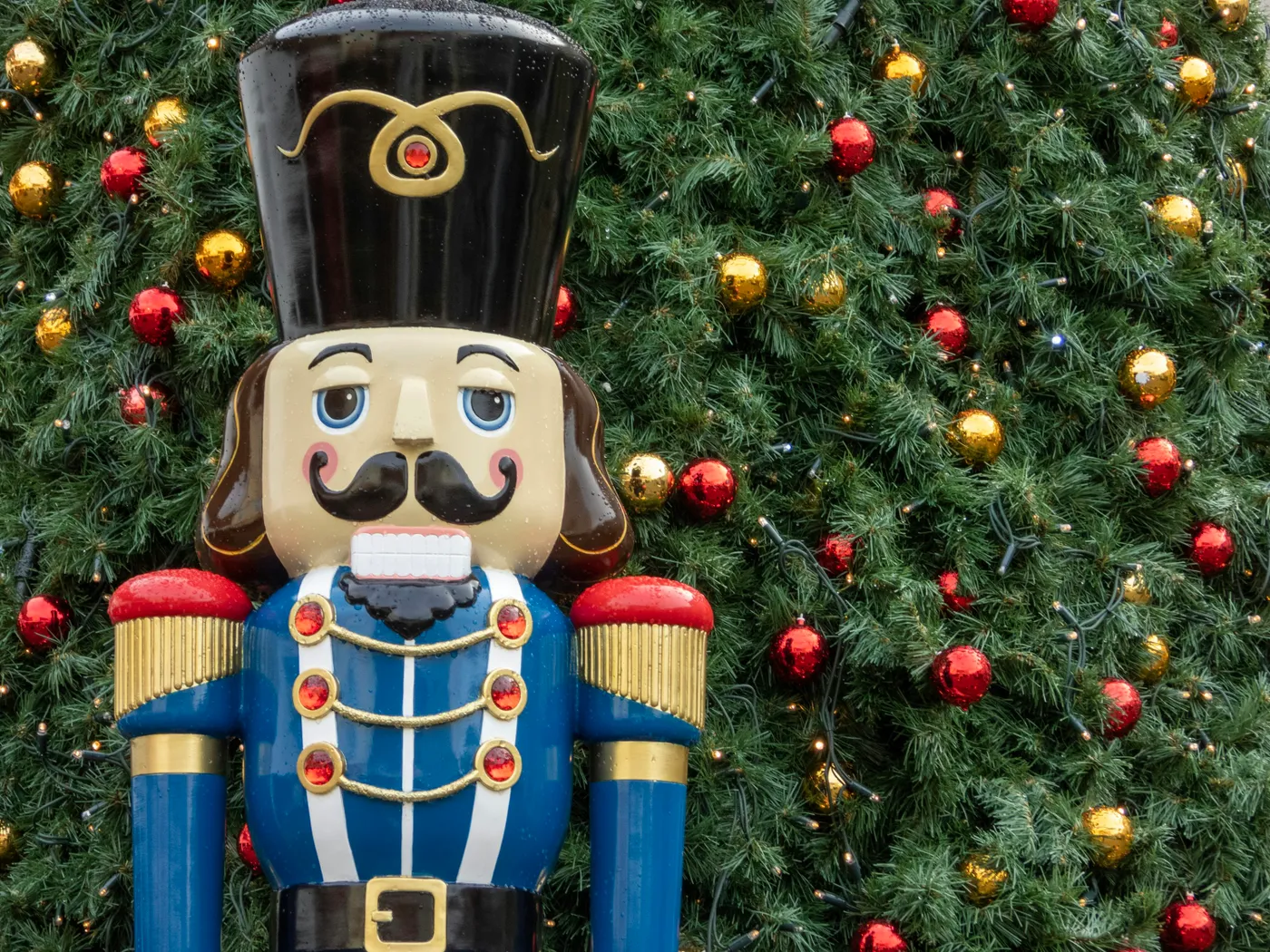 Nutcracker beside Christmas tree with baubles - Free Photo on Unsplash