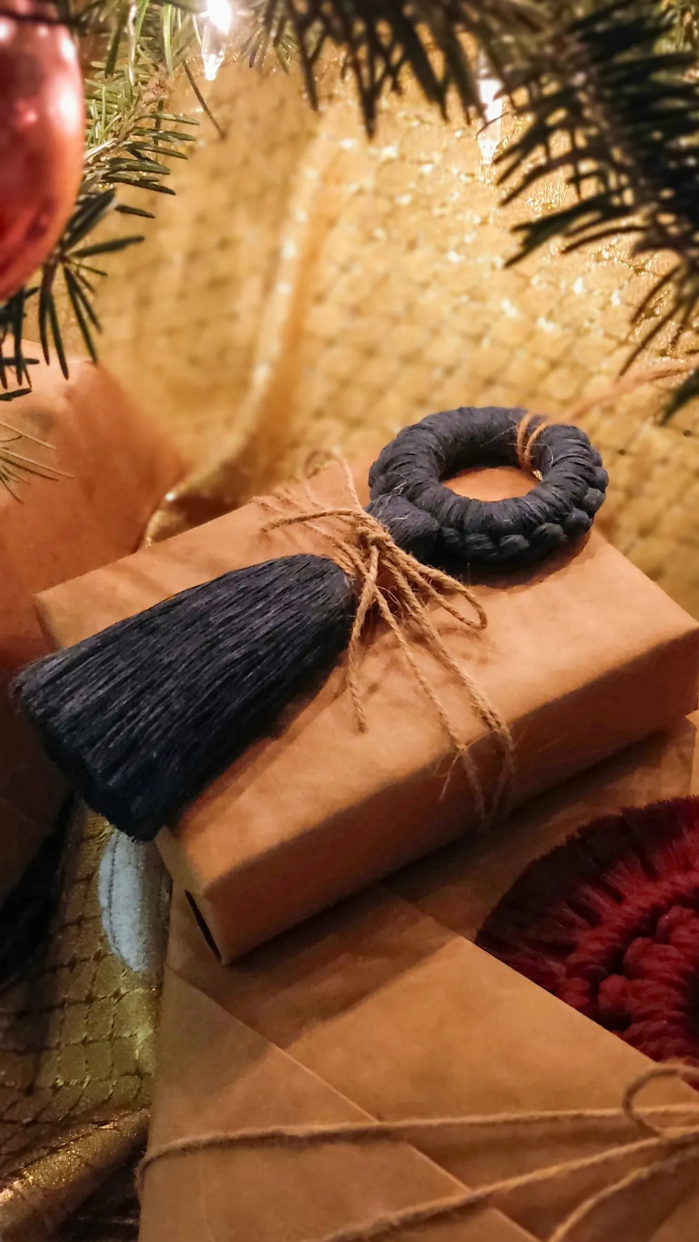 Rustic brown paper gifts under a Christmas tree with macrame ornaments and natural twine for an eco-friendly holiday.