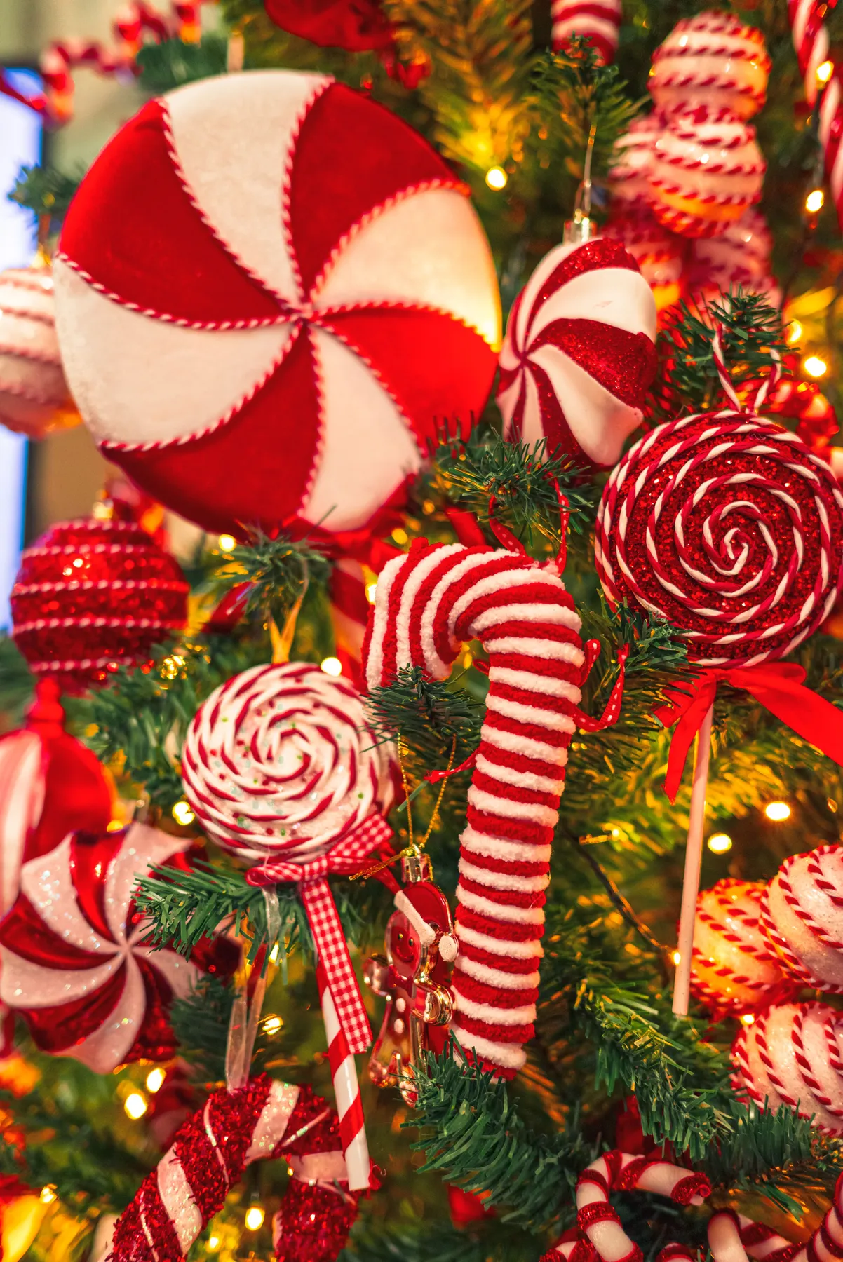 Vibrant Christmas tree adorned with handmade candy-themed ornaments and twinkling lights.