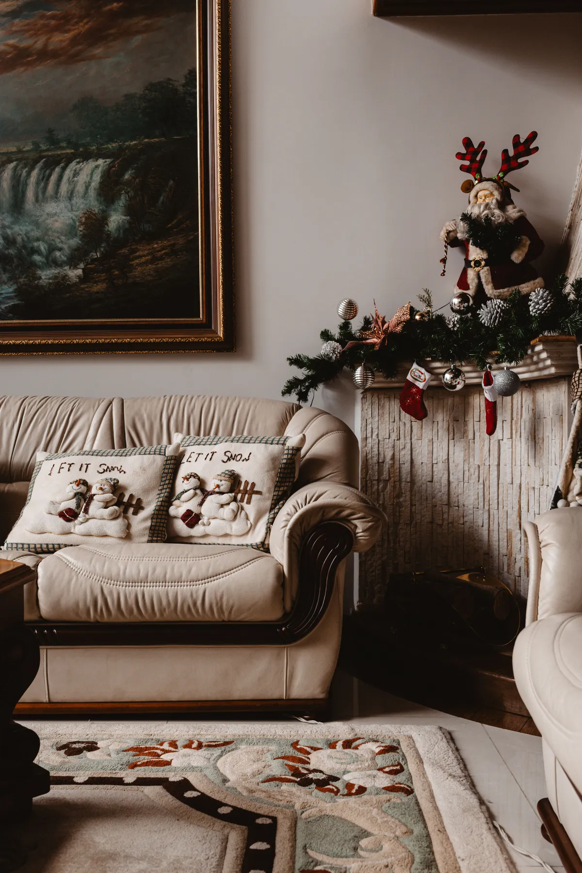Warm and inviting living room with holiday decor including a fireplace and Christmas pillows.
