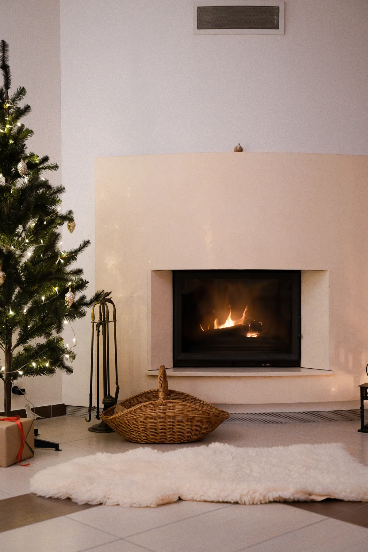 Warm festive interior with a Christmas tree and fireplace setting the holiday mood.